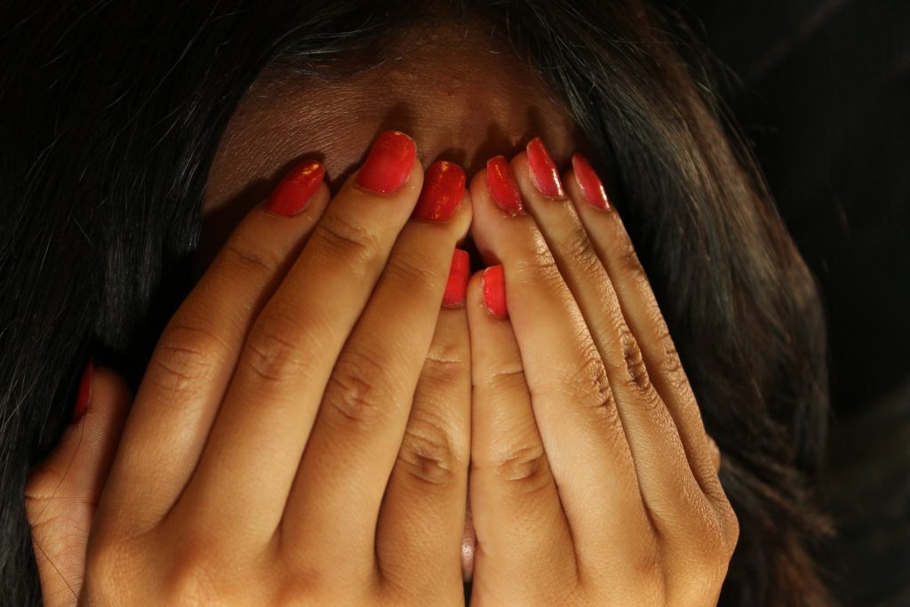 girl in shame covering face